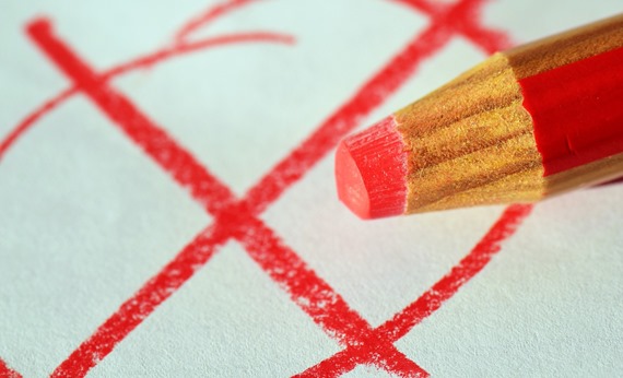 Kryds skrevet på papir med rød farveblyant