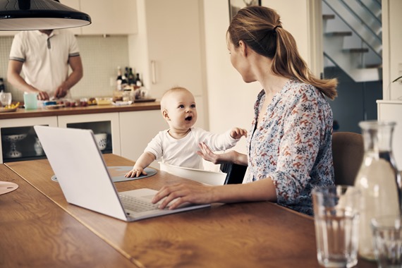 Kvinde med baby arbejder ved computer
